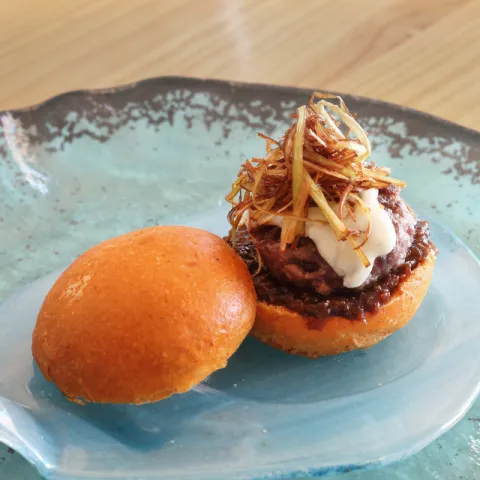 Panecillo relleno de chuletón de ternera con mermelada de beicon y Malvasía de Sitges, crujiente de puerro y suave queso azul