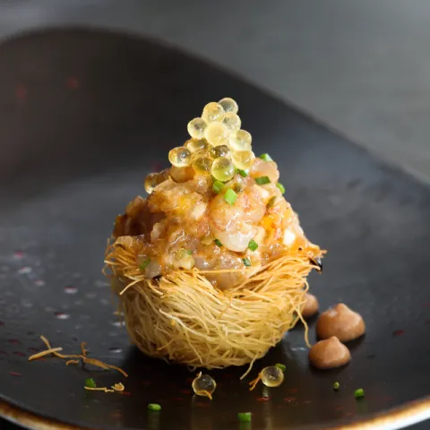 Pasta kataifi, langostinos, mango, vinagreta de escalonia, soja, caviar de aceite de sésamo, alioli de chocolate, cebollino fresco, alcaparras y pepinillo