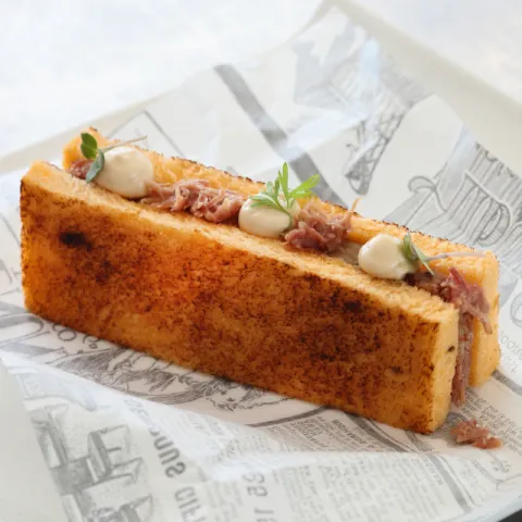 Sándwich de pan de molde de tomate con carne de pato deshilachada, fuagrás y pera