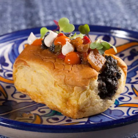 Mini brioix torradet farcit de butifarra esparracada amb sípia a la brutesca, allioli de mongetes del ganxet, tàrtar de samfaina i romesco de kimchi.