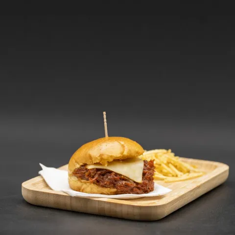 Mini brioche tierno relleno de pulled pork jugoso y meloso, acompañado de coleslaw casera. Coronado con patatillas paja crujientes