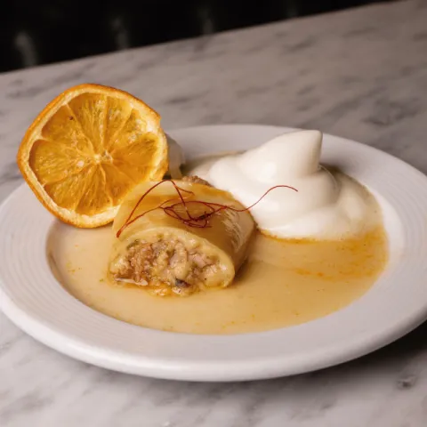 Canelón de cochinillo de can Company con reducción de Miss vermut y espuma de naranja
