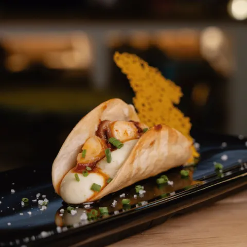 Teja de pan con herbes dolces rellena de crema de patata con nata y coronada con pulpo mallorquín cocinado con Tap de Cortí