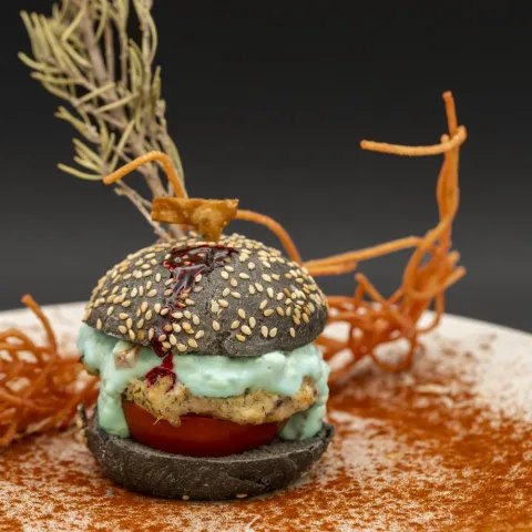 Hamburguesa de jibia en pan negro con alioli de pepino y calabacín estilo municipal