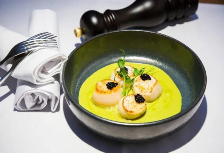 Vieires a la brasa amb crema de pèsols, coco i oli cítric