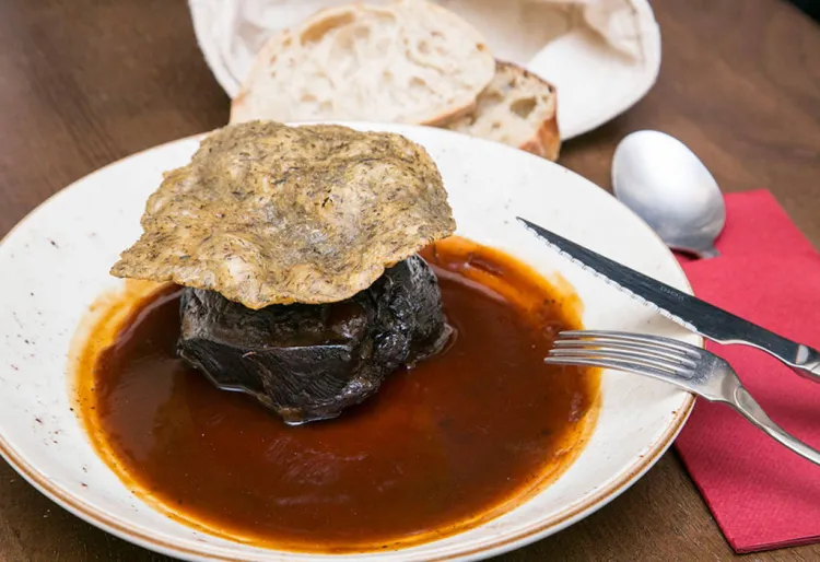 Galta de vaca madurada a la ratafia amb pa de farigola cruixent