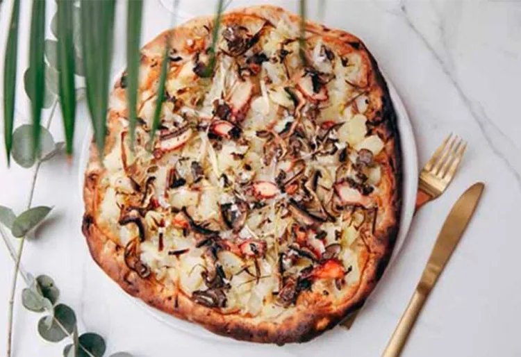 Pizza de pop, formatge fumat, porros, bolets, oli de tòfona i patates