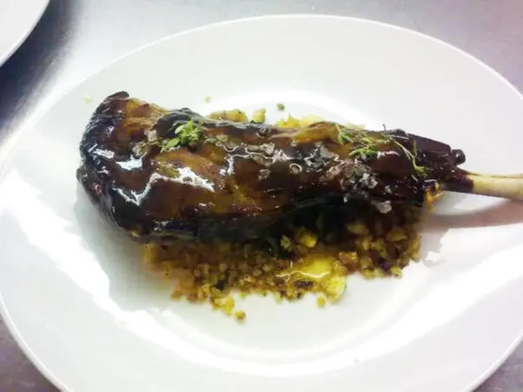 Espatlla de cabrit en el seu suc de cocció amb 'migas' i poma glacejada